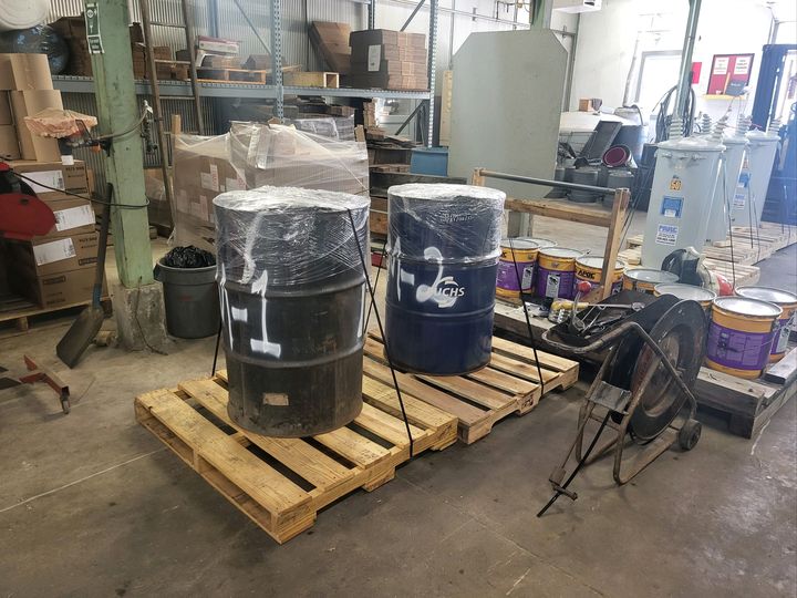 Wrapped drums strapped on pallets in a workshop (Packaging and hauling) by Affordable Moving Solutions of Ohio