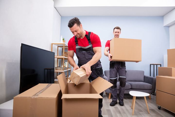 Movers unpacking boxes in a living room (Unpacking Services) by Affordable Moving Solutions of Ohio